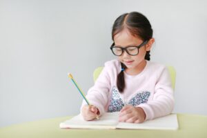 Young girl writing in a notepad