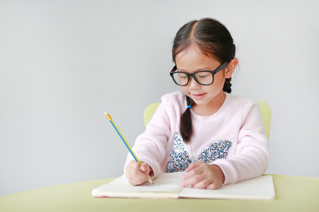 Young girl writing in a notepad