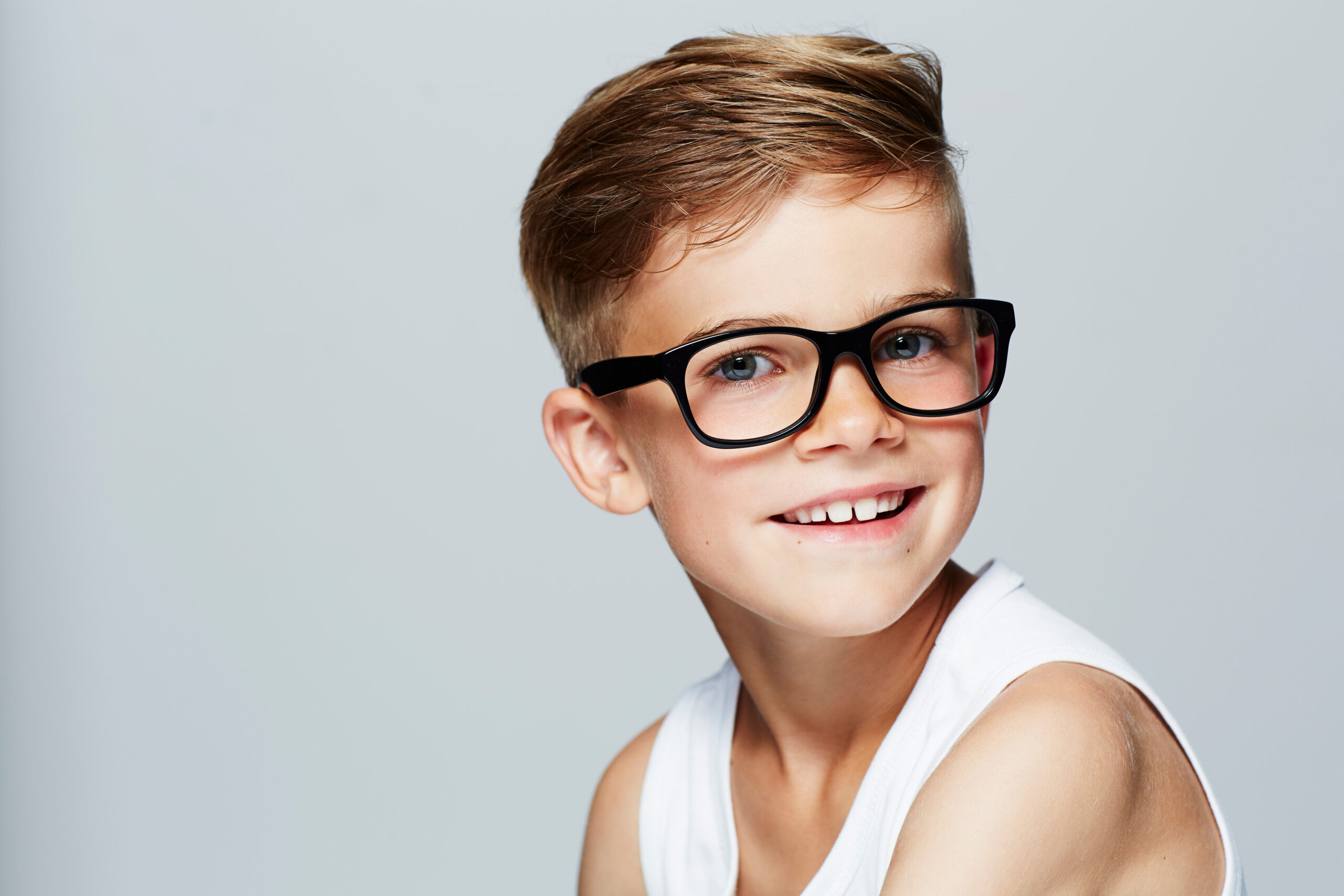 Portrait of young boy wearing glasses, studio. BTown Eyecare