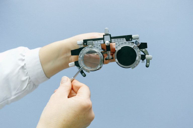 crop unrecognizable doctor with vision test device